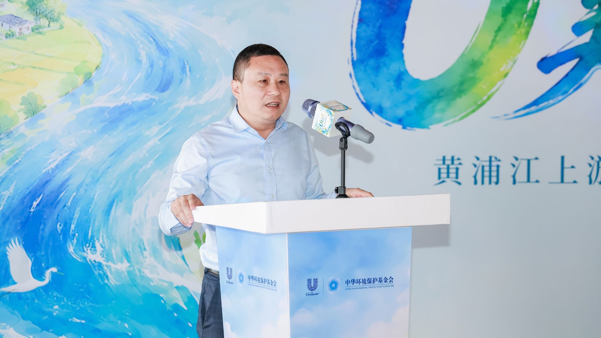 一名男子在环保活动中站在讲台上发表演讲。